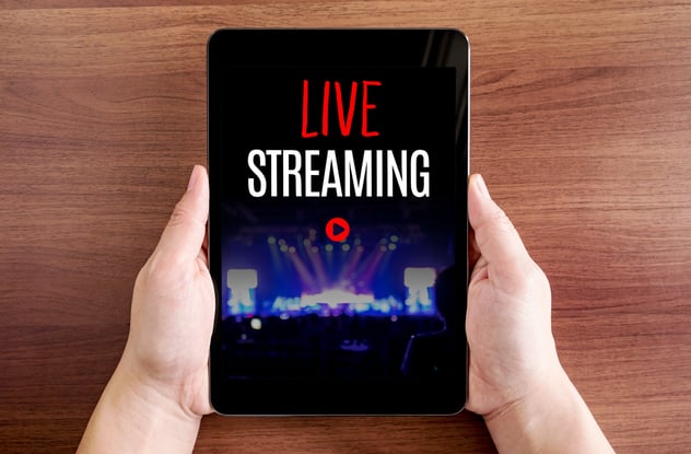a person holding a tablet with live streaming on