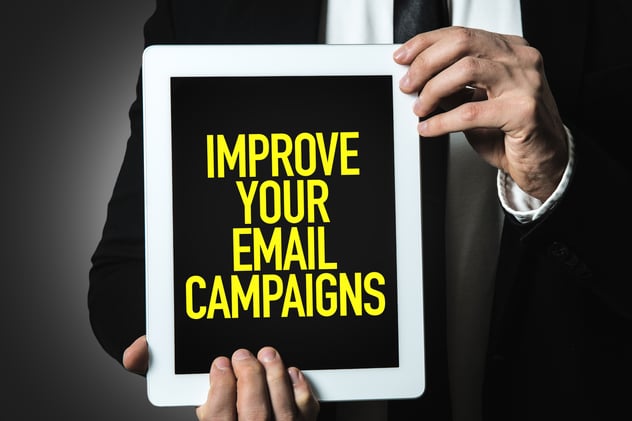 a man holding a tablet with a text improve your email campaign