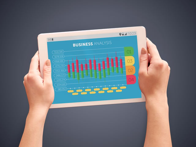two hands holding a tablet with business analytics 