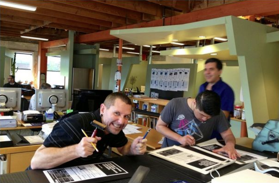 man holding pencils with coworkers