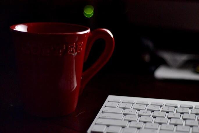 A red cup beside the keyboard