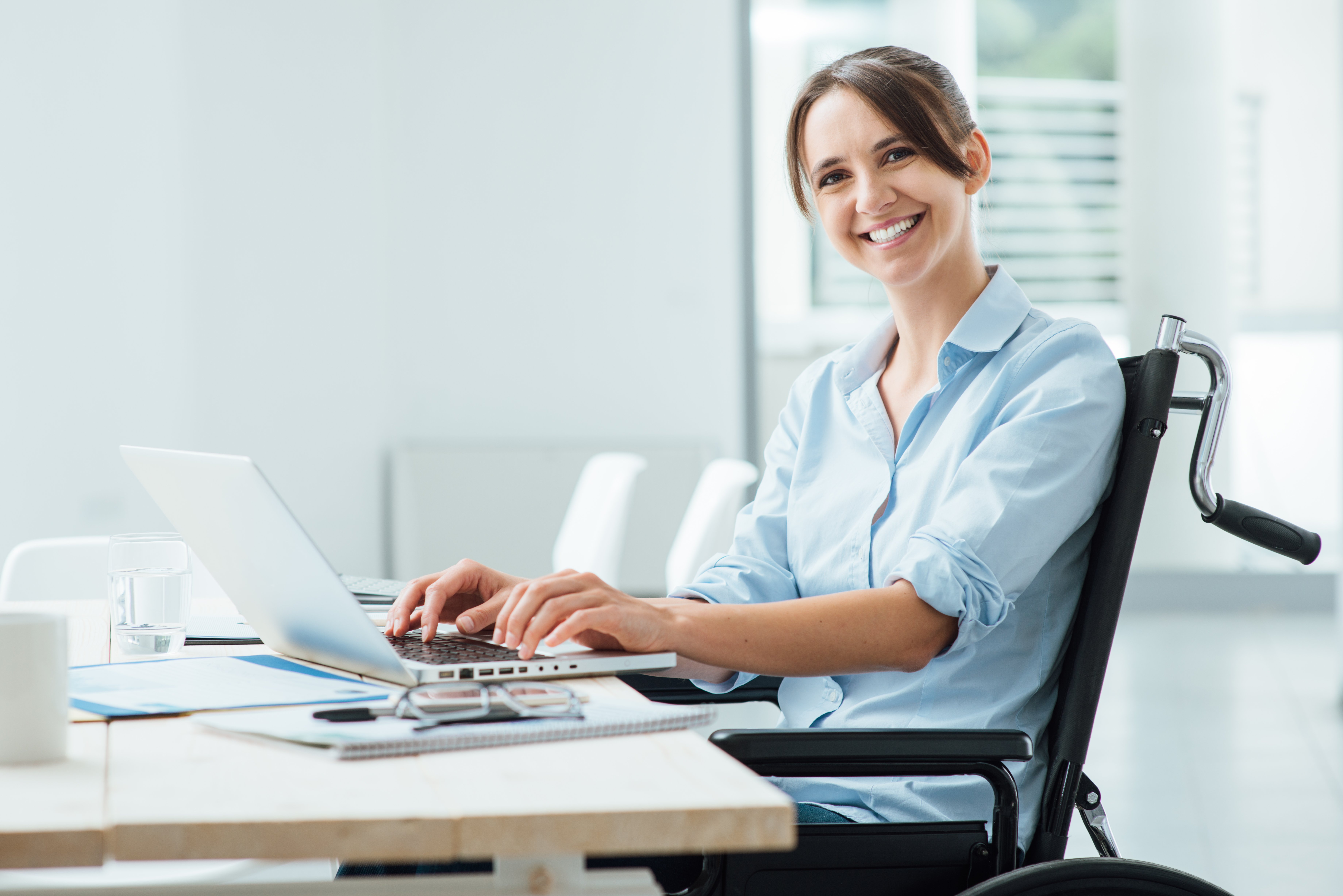A woman sitting in front of her laptop smiling.