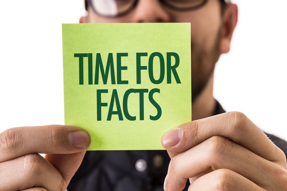 a man holding a note time for facts