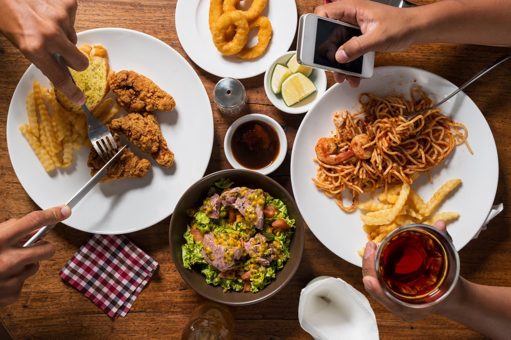 a man taking a photo of the foods on the table