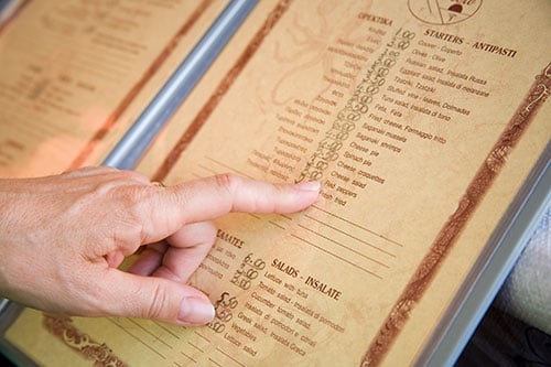  a hand pointing on a menu book