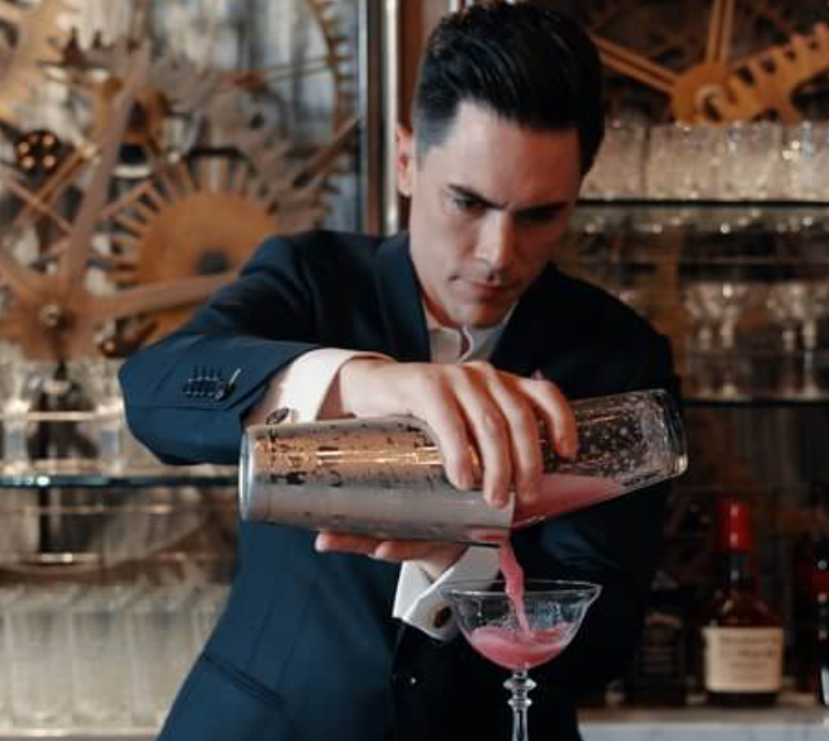 A bartender pouring the mixed drink