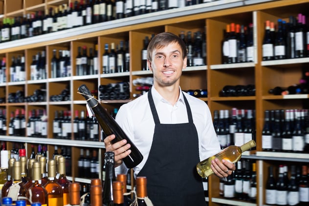 a man holding two bottles of wine