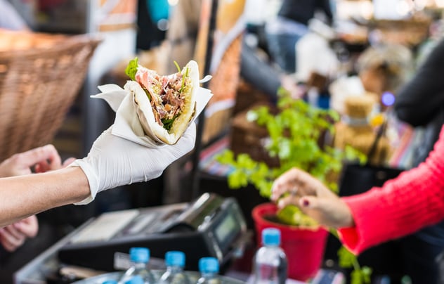 A man handing taco to the woman