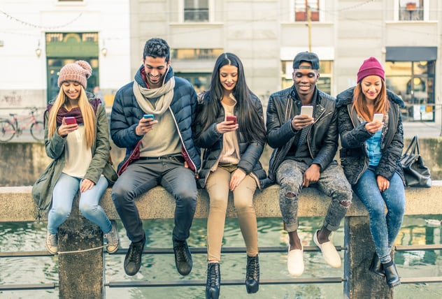 a group of people sitting while looking at their phones