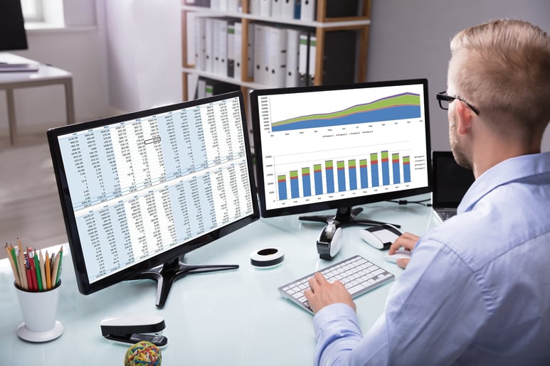 A man working on graphs through his computer