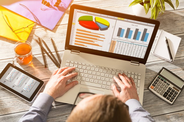 a man working on his laptop with graphs