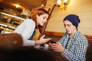 man and woman discussing over a phone