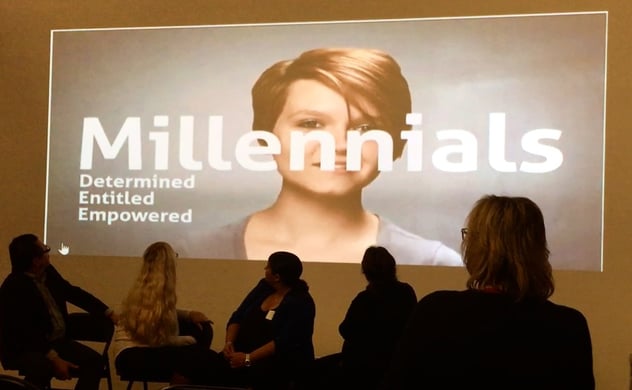 group of people watching over a wide monitor