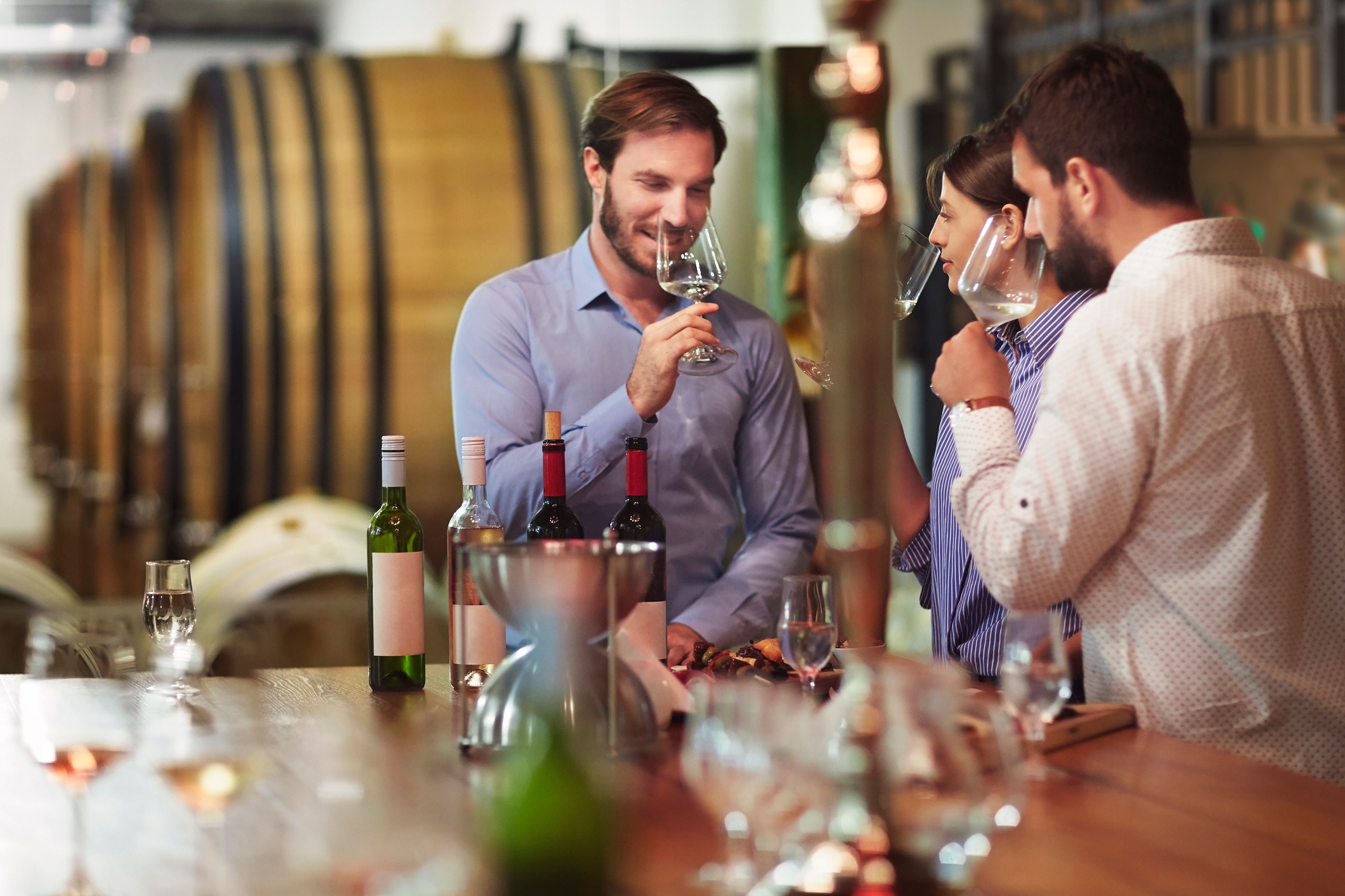 Two guys and a lady drinking wine