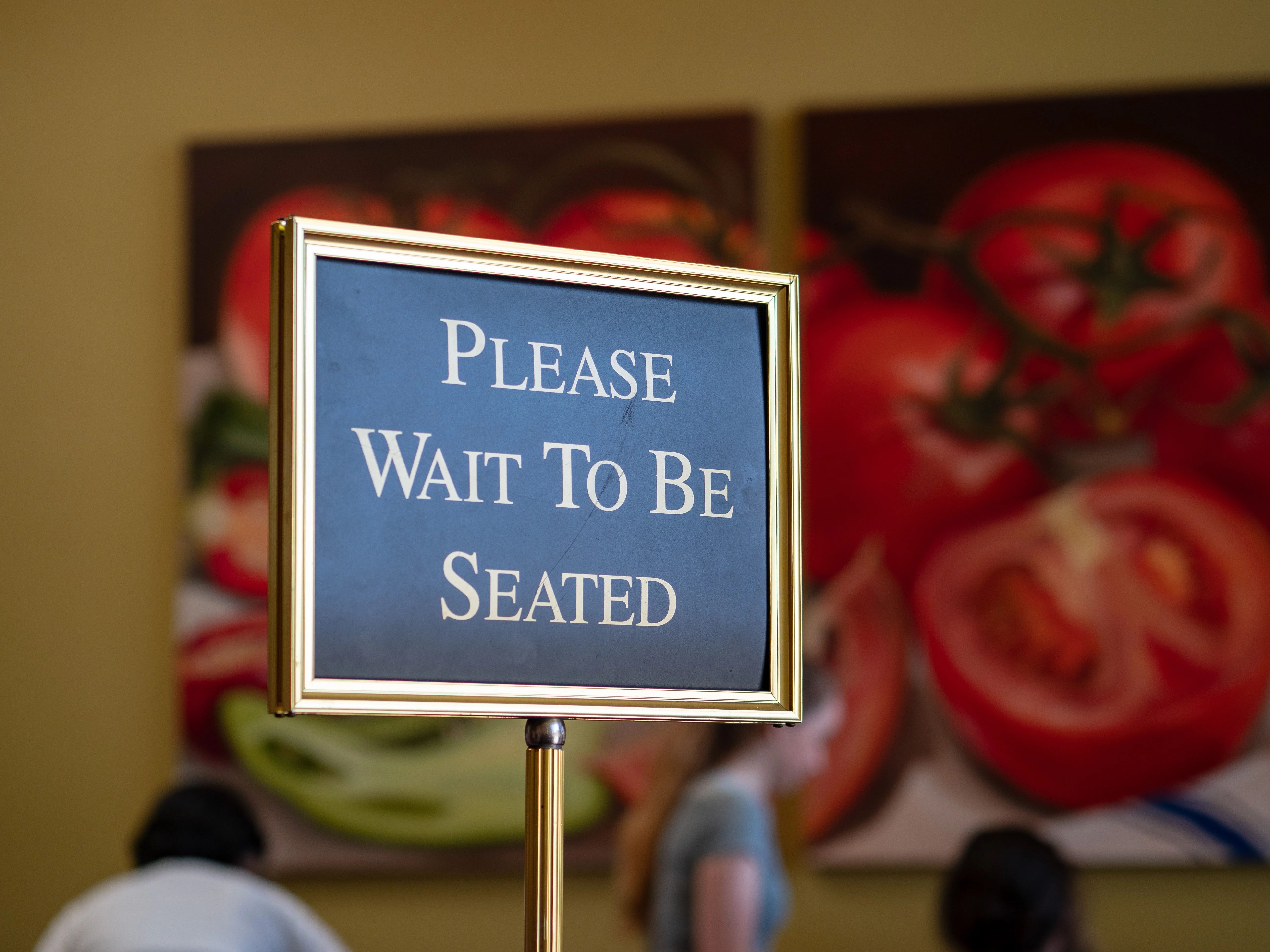 A placard saying please wait to be seated